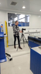 Industrie-Fotografie. Making-Of bei einem Fototermin. Ein Fotograf bedient eine Kamera und steht vor einer Anlage